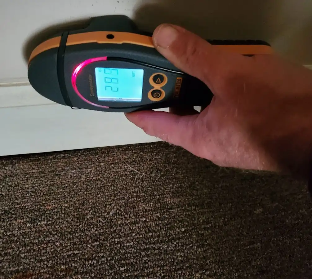 Moisture detection at baseboard during Storm Damage Restoration in Crandall